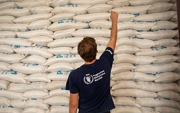 WFP staff member with stacked food aid bags in Haiti